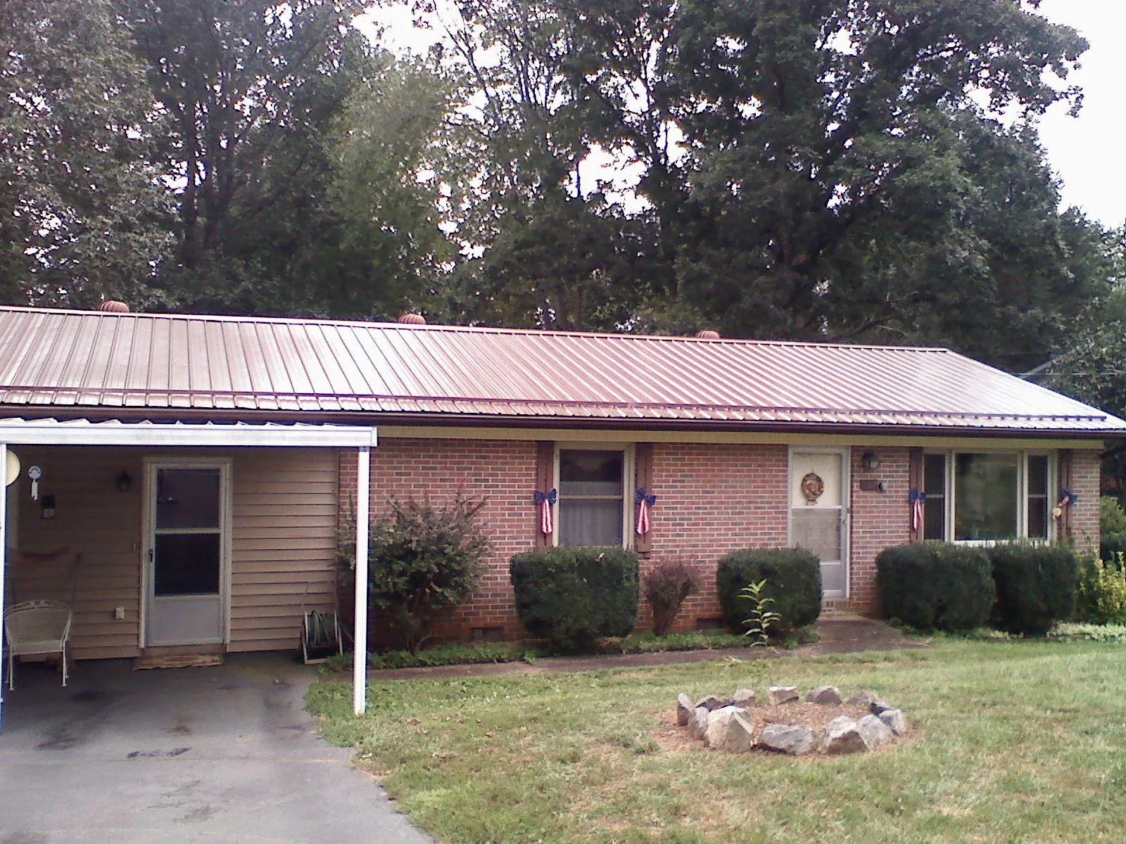 Bronze metal roof and carport on a brick ranch home — Roof Repair work by our crew in Neilton